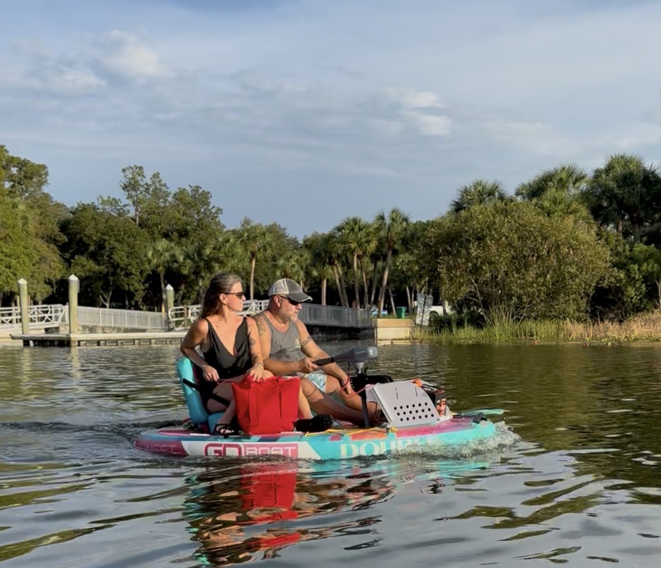 A couple cruising together on a Coastal Cruisers Double GoBoat at golden hour